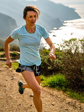 Women running on a trail overlooking the ocean