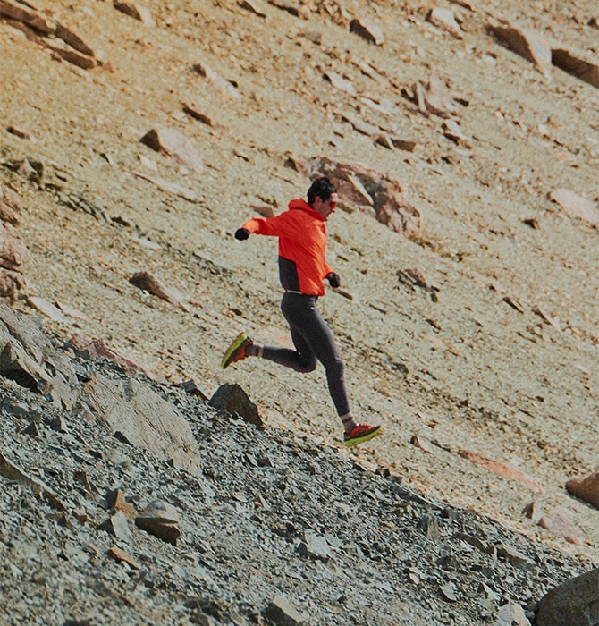 Medium shot of a runner descending a mountain