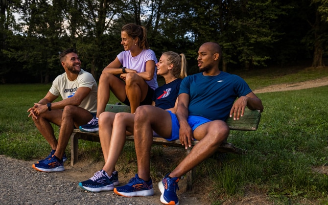 Un coureur s’étire en riant avec deux autres coureurs