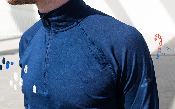 A close-up shot of a man wearing a navy Brooks half-zip