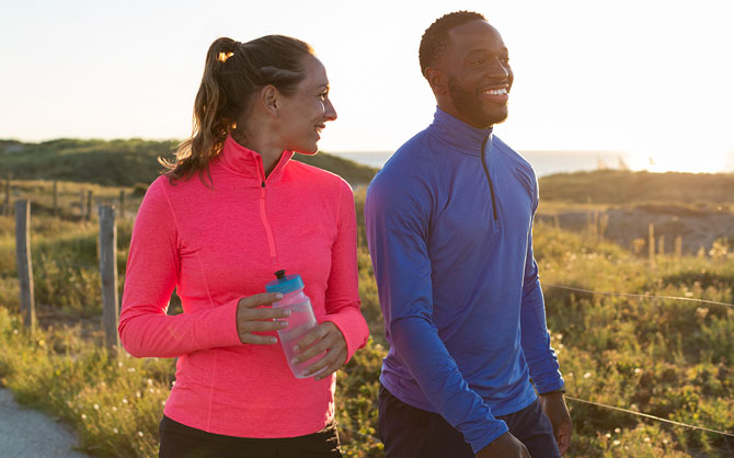 Two runners smiling on a trail