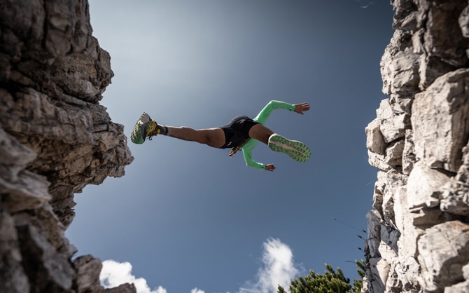 Trail runner jumping from one mountain to the other