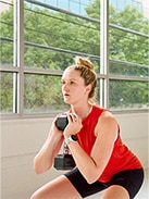 Women doing a squat in front of bright window