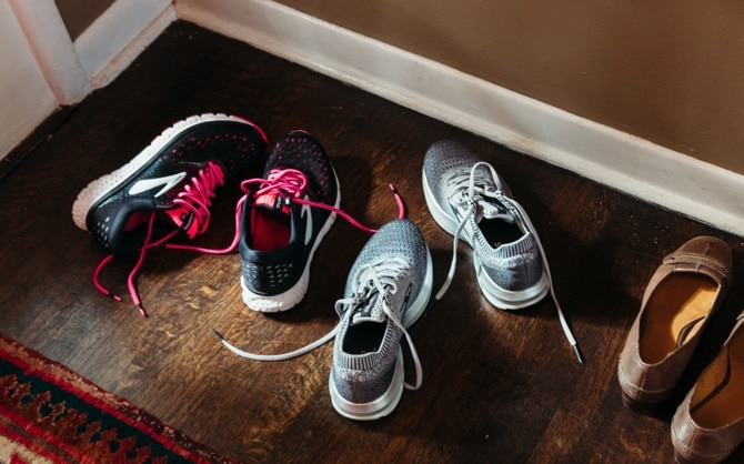 Trois paires de chaussures devant la porte d’entrée d’une maison.