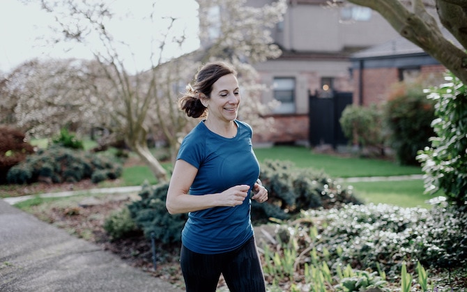 Runner running by a tennis court