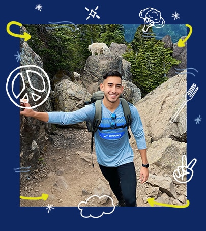 A man on a hike, smiling at the camera