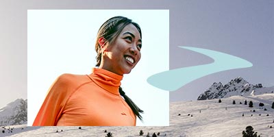 Woman smiling with a snowy scene and Brooks logo in background.