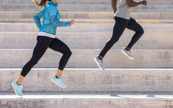 Dos corredores hacen jogging junto a una pared pintada