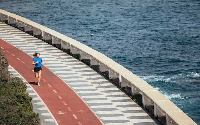 Una donna che corre in pista vista mare