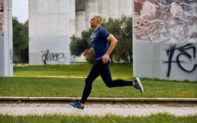 Male runner running through a park