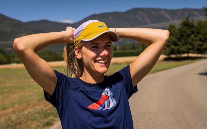 Un coureur souriant porte un chapeau pour protéger sa peau avant une course à pied.