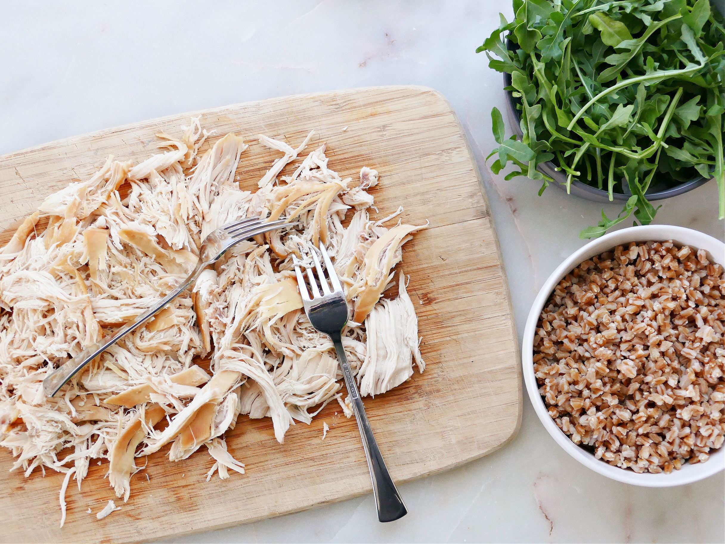 a cutting board with shredded chicken