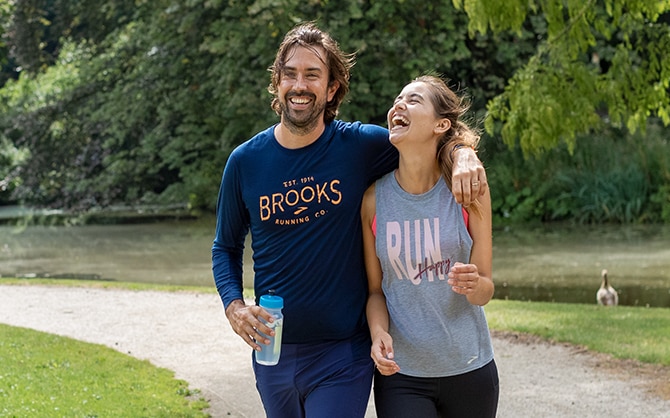 A man with his arm around a laughing woman.