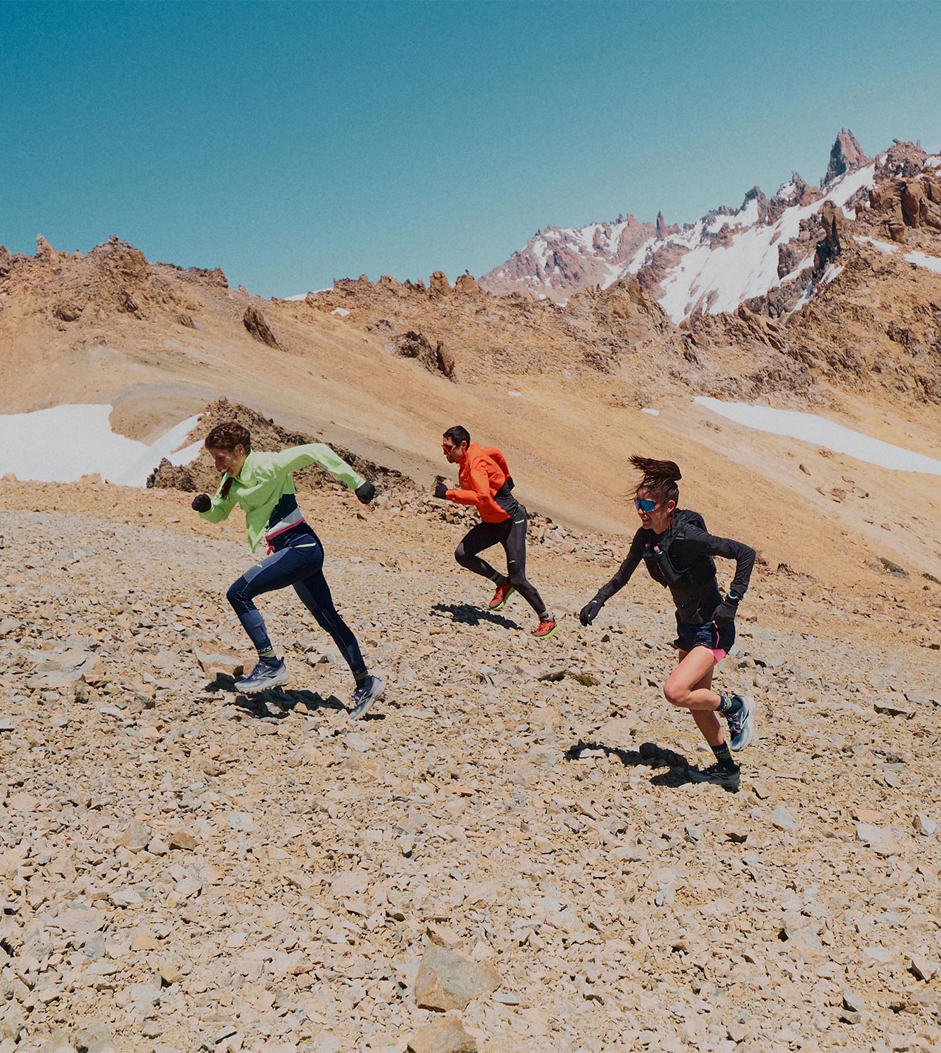 Plano medio de un grupo de corredores de trail con equipación de trail de Brooks Running subiendo una montaña