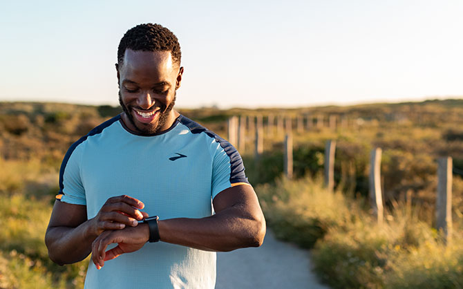 Runner checks watch on trail