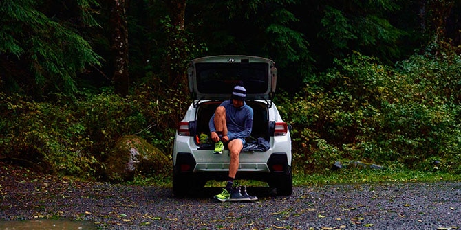 JP lacing up running shoes in his car.