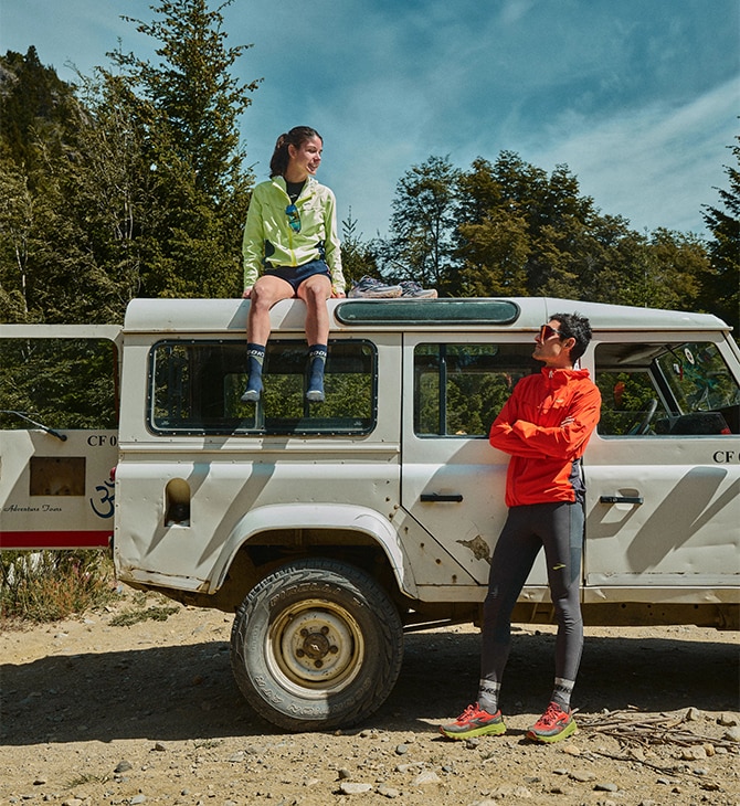 Medium shot of a group of a woman and a man wearing posing with a car