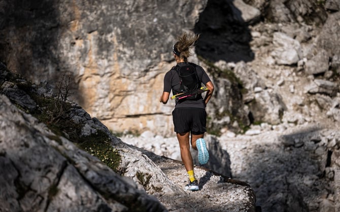 Trail runner che corre sul crinale di una montagna