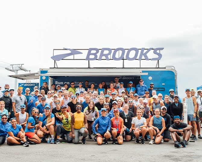 Happy runners in front of Brooks sign