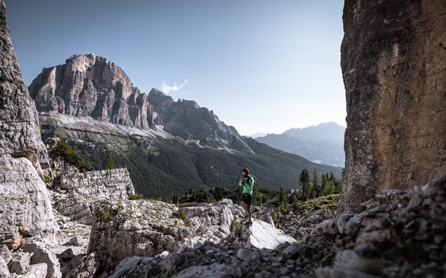 Due runner in montagna con il sole che spunta tra le nuvole